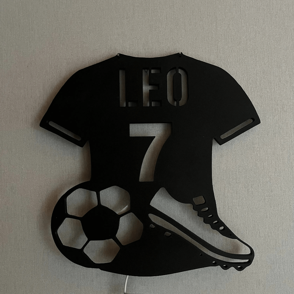 Décoration murale foot, personnalisable avec prénom et numéro. Design maillot avec ballon et chaussure, idéal pour fans de football.